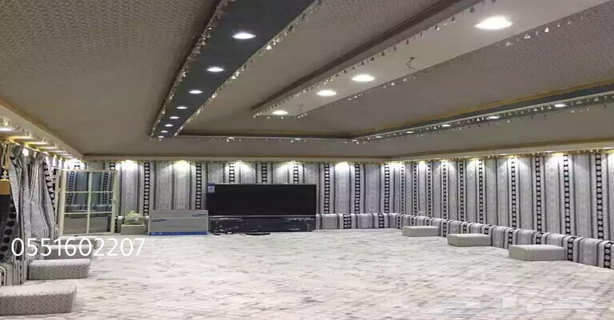 بيت شعر في مزرعة خاصة محاط بأشجار نخيل وأثاث تراثي خارجي